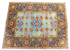 A Persian rug, with a design of flower heads, scrolls, in various colours, on a blue ground, with on
