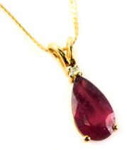 A ruby and diamond pendant, the teardrop shaped ruby in a raised basket setting, tiny diamond to top