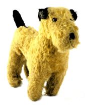 A 1930's plush toy terrier, in gold with black tail and ears, 28cm long.