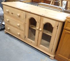 A pine sideboard, with arrangement of three drawers and two glazed doors.