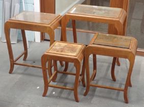 A nest of four Oriental hardwood carved tables, with glass tops.