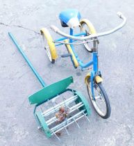 A child's tricycle and a lawn aerator.