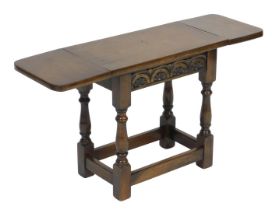 An Old Charm oak drop leaf occasional table, raised on baluster turned supports united by a box stre