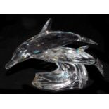 A pair of Swarovski crystal dolphins, modelled riding the crest of a wave, 12.5cm long.