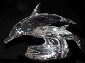 A pair of Swarovski crystal dolphins, modelled riding the crest of a wave, 12.5cm long.