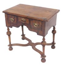 A late 18thC walnut lowboy, the rounded top raised above three frieze drawers, on turned legs, termi