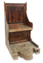 A stained pine Gothic style throne chair, the two seat back with carved detailing, on a later base,