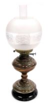 An early 20thC duplex copper oil lamp, with embossed foliate decoration, on a socle base, glass chim