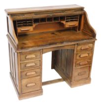 A Victorian oak roll top desk, the tambour front opening to reveal drawers and recesses, raised on t