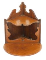 An early 20thC mahogany hanging corner shelf, with semi circular top, above shaped under section, wi