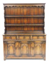 An Old Charm oak dresser, the plate rack with an outswept pediment over two shelves, above three fri