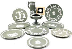 A group of Wedgwood green Jasperware, including plates, tazza, plaque, circular dish, and a framed c