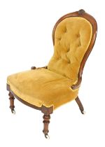 A Victorian mahogany spoon back nursing chair, with overstuffed button back gold fabric and overstuf
