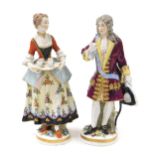 A pair of late 19thC Vienna style porcelain figures, of a gallant, and a lady offering refreshments