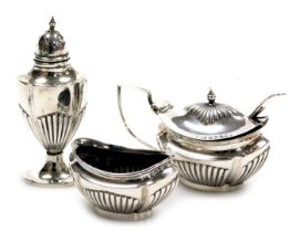 An Edward VII/George V silver three piece condiment set, of semi fluted form, comprising salt, pepp