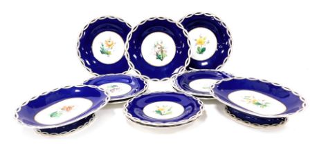 A late 19thC porcelain part dessert service, painted with flowers against a cobalt blue ground, bear