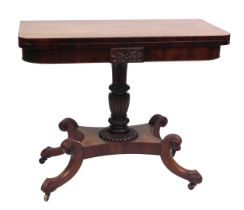 A George IV mahogany fold over tea table, raised on a fluted and foliate carved column, above a quat