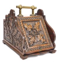 A Victorian oak coal box, with brass carrying handle, carved to the sides and hinged lid, with holly