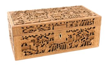 A late 19thC Chinese wooden box, of rectangular section, profusely carved with figures in a garden,