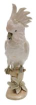 A Royal Dux porcelain figure of a cockatoo, modelled perched on a branch, on a naturalistic base, nu