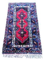 A Turkish Sultankoy red ground rug, the central field decorated with three floral, cross motifs, wit