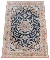 A Belgian style blue ground rug, decorated with floral and foliate motifs, within repeating floral b