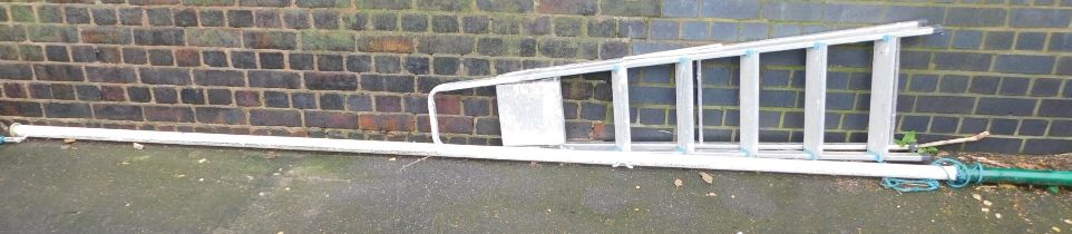 A white painted flag pole and an aluminium step ladder.