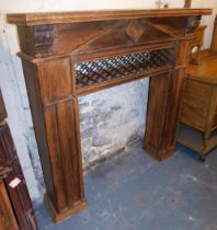 An oak fireplace surround, with carved leaf finials and metal cross section, on two plinth columns,