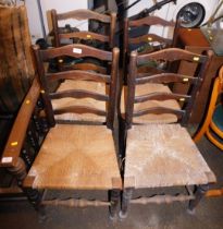 A set of four 20thC rush seated oak ladder back dining chairs.