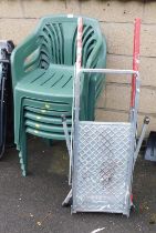 Green stacking garden chairs and a folding metal step ladder.