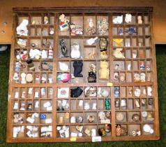 A wooden rack containing various owl figures, other figures and thimbles.