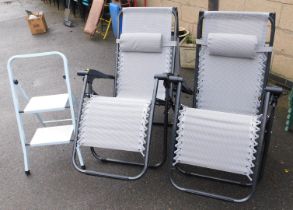 A blue finished two tier step ladder and two reclining chairs.