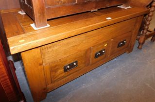 A hardwood rectangular coffee table, with slatted top above arrangement of three drawers.