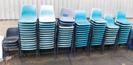 A large quantity of plastic stacking chairs.