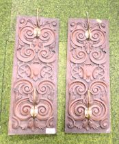 Two wall hanging plaques, with brass fittings and a carving to front.