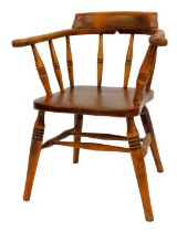 A late 19thC oak and elm captain's bow chair, with a solid seat, raised on ring turned legs united b