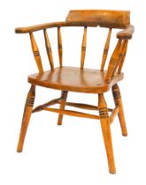 A late 19thC oak and elm captain's bow chair, with a solid seat, raised on ring turned legs united b
