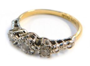 An early 20thC 18ct gold three stone diamond ring, illusion set, with platinum mount, size R 1/2,