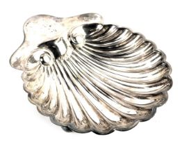 An Edward VII silver butter dish, of scallop shell form, raised on three ball feet, London 1902, 2.3