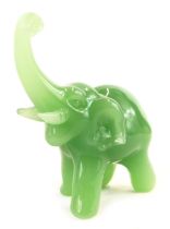 A 20thC jade figure modelled as an elephant, with trunk raised, 8.5cm high.