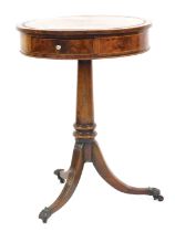 A George III mahogany drum table, with two frieze drawers, raised on an out swept and turned column