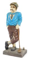 A mid century painted wooden figure of a golfer, raised on a rectangular base, 101cm high.