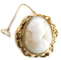 A 19thC oval cameo brooch, carved with a bust of a Roman lady, within a yellow metal scroll mount wi