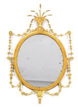 A 19thC giltwood mirror, the oval mirror in a raised bead and line decorated surround surmounted by