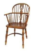An early 19thC oak and elm Windsor chair, with a pierced splat, solid saddle seat, raised on turned