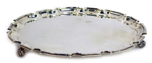 A George V silver salver, with piecrust border, raised on three scrolling feet, William Hutton and S