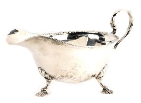 A George VI silver sauce boat, with a gadrooned rim raised on three shell cast feet, Mappin and Webb