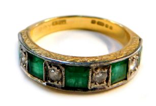 An Elizabeth II emerald and diamond dress ring, channel set, with miligrain borders and floral engra