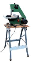 An electric band saw, on stand.