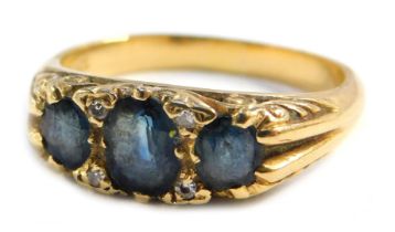 A sapphire and diamond dress ring, set with three marquise cut sapphires, with tiny diamond breaks,
